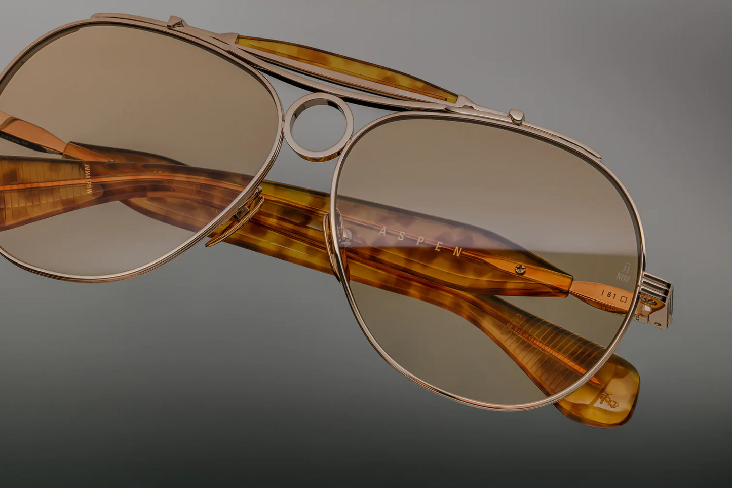 Jacques Marie Mage Aspen sunglass frames in a shooter style; gold with bottle green lenses.