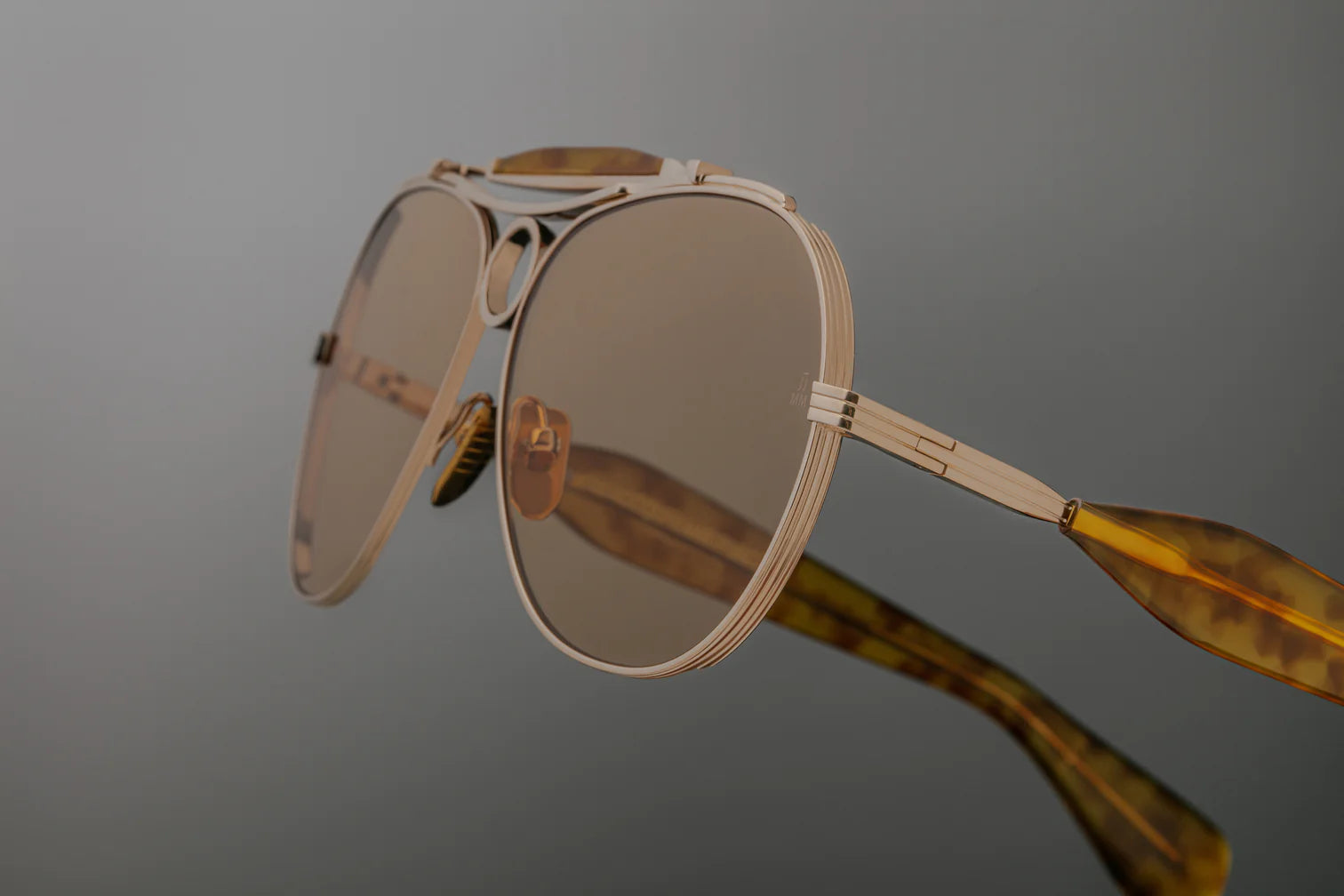 Jacques Marie Mage Aspen sunglass frames in a shooter style; gold with bottle green lenses.